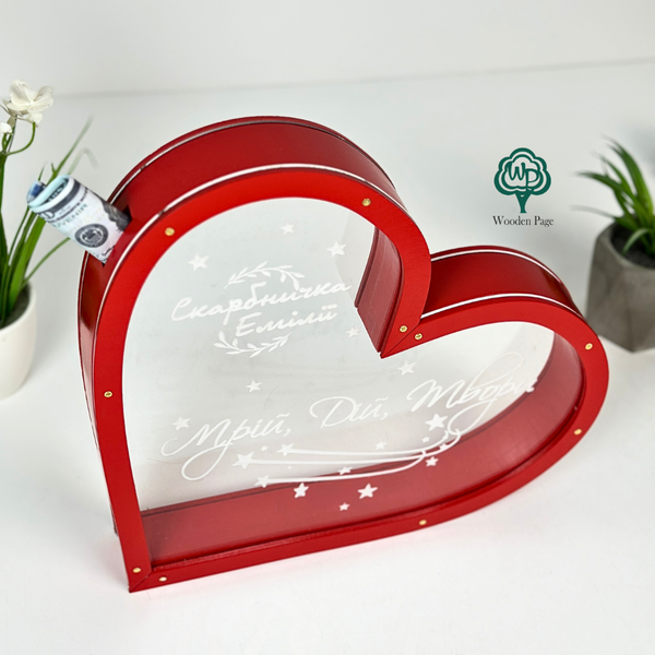 Wooden piggy bank in the shape of a heart with transparent walls