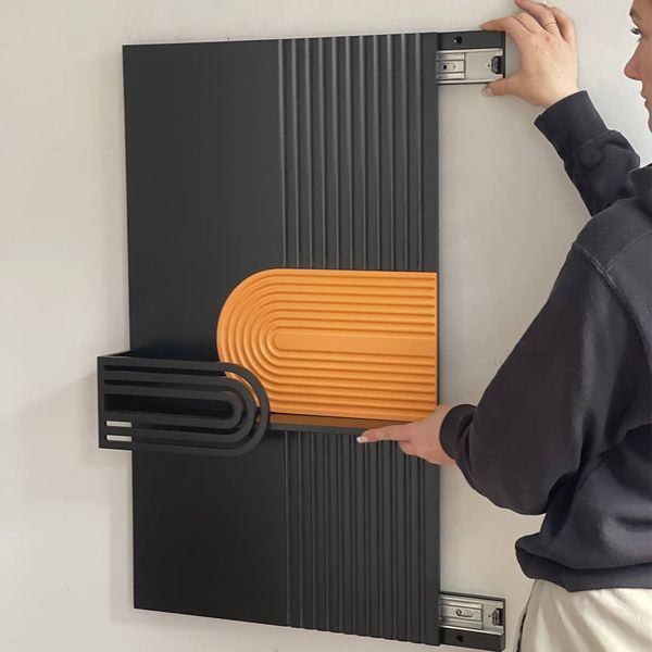 Designer wall key holder under the shield with a slider system