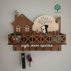 Wooden house key holder with the name of the Cats family under a lantern