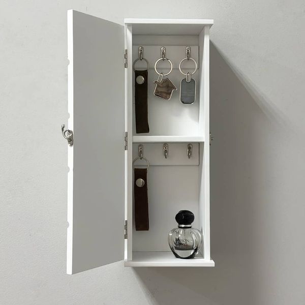 Designer wooden key holder with a door on the wall