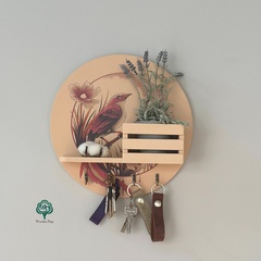 Round wall-mounted key holder with a bird