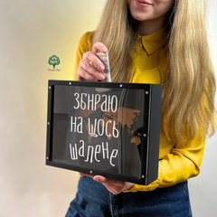 Wooden money box with engraving "We're collecting for something crazy"