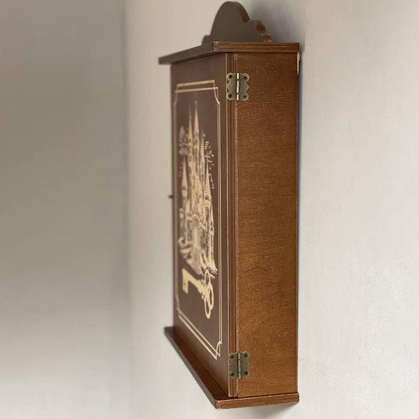 Wall mounted key holder with a door with a picture of a castle