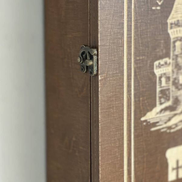 Wall mounted key holder with a door with a picture of a castle